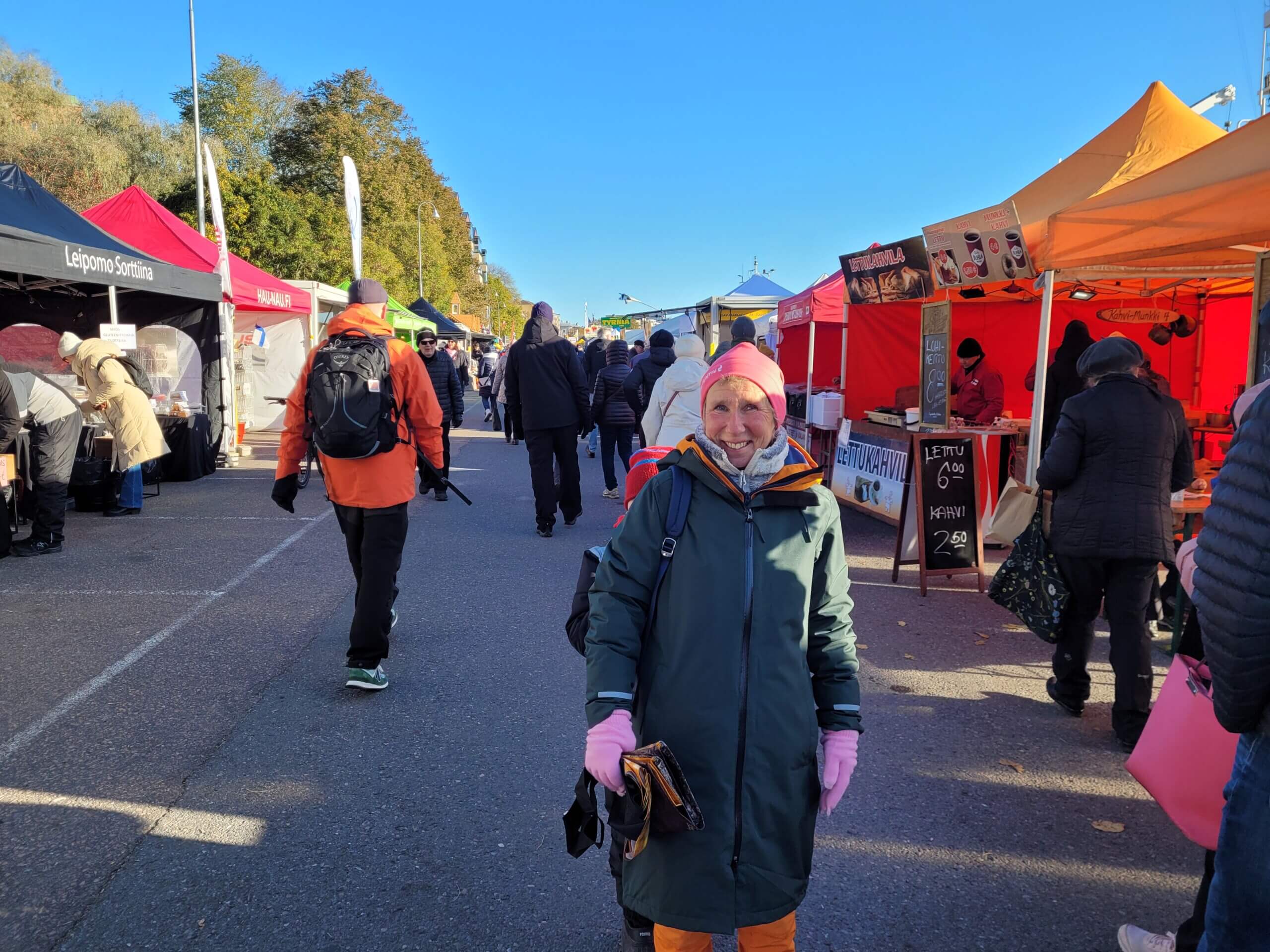 En kvinna ler mot kameran, bakom henne skymtar en liten pojke.