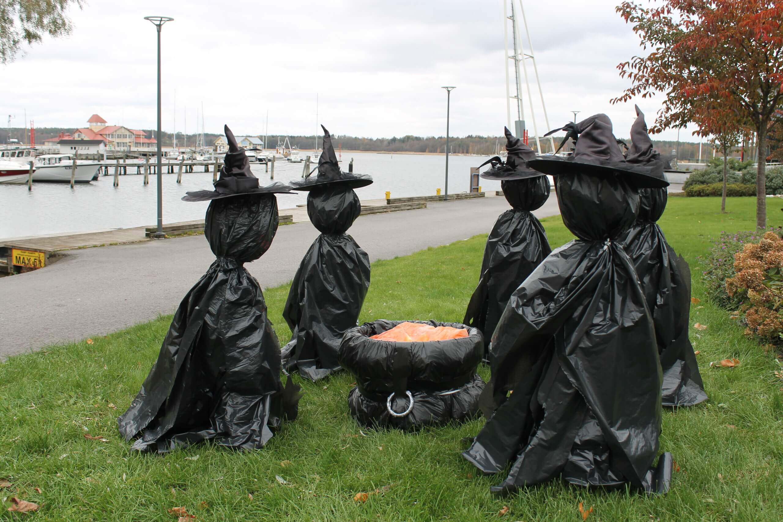 Halloweendekorationer i Ekenäs. På bilden ser man flera häxor gjorda av svart sopsäckar.