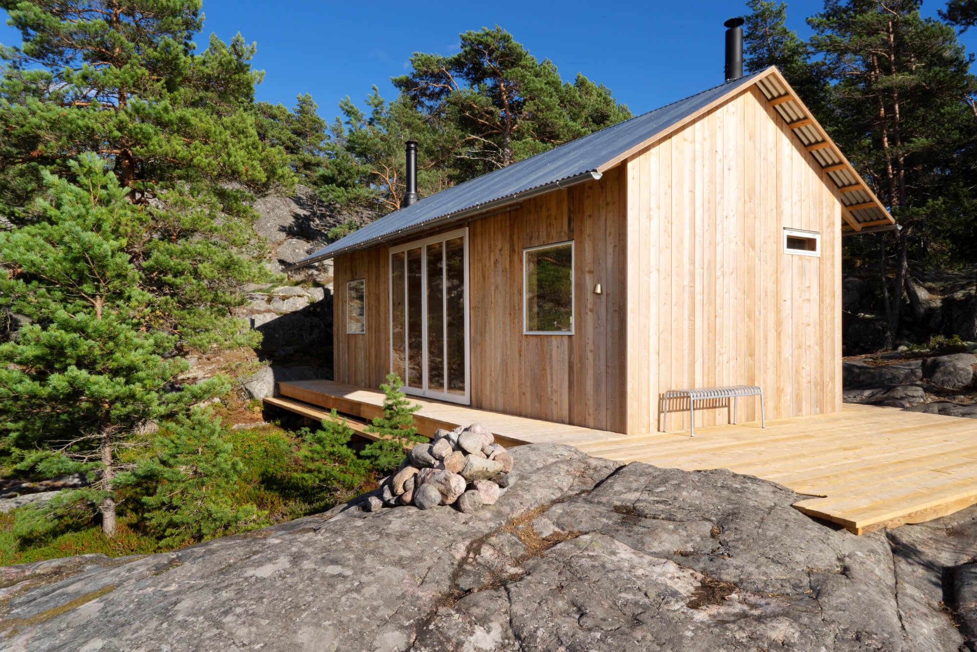 Bastu i ljust trä på klippa i skärgården.