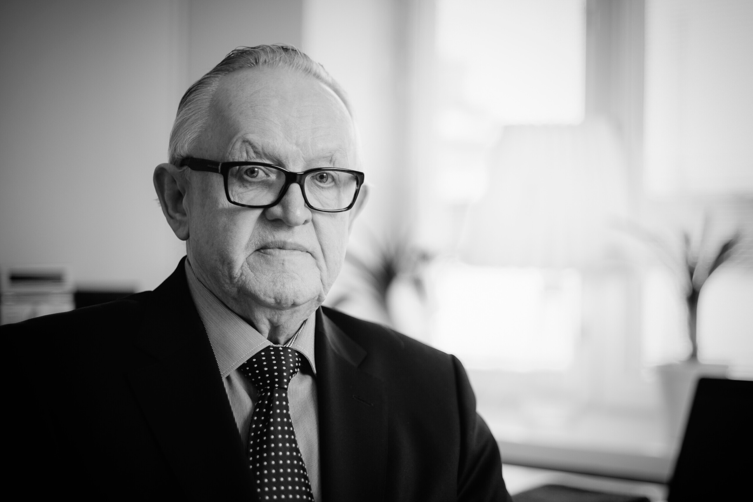 Svartvit bild på äldre karl i slips och kostym
