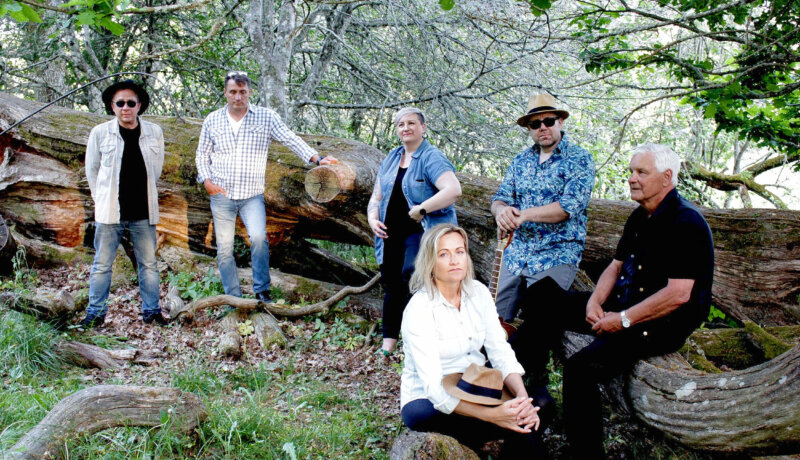 ett band poserar ute i naturen