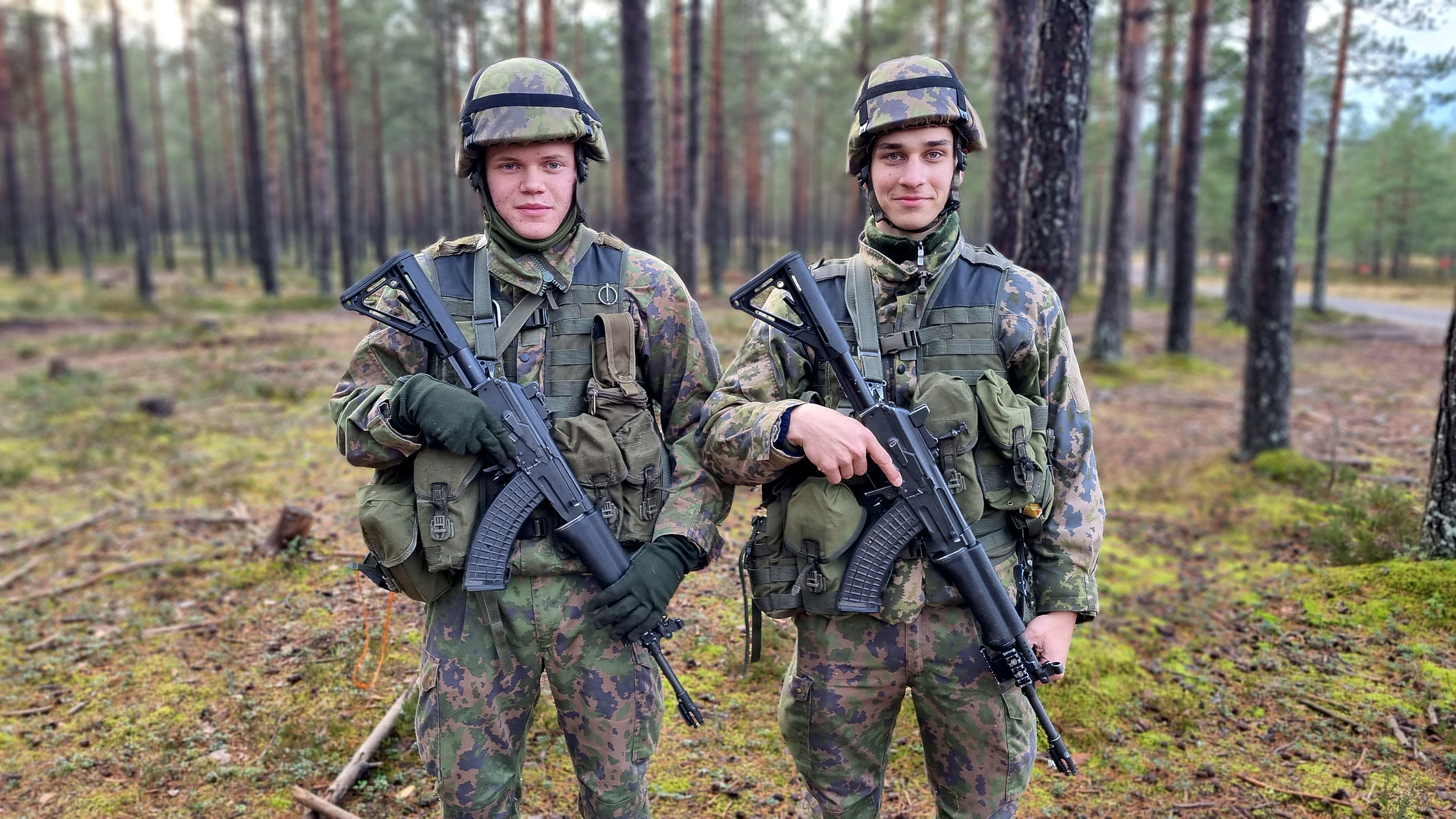 Två soldater med gevär i skogen.