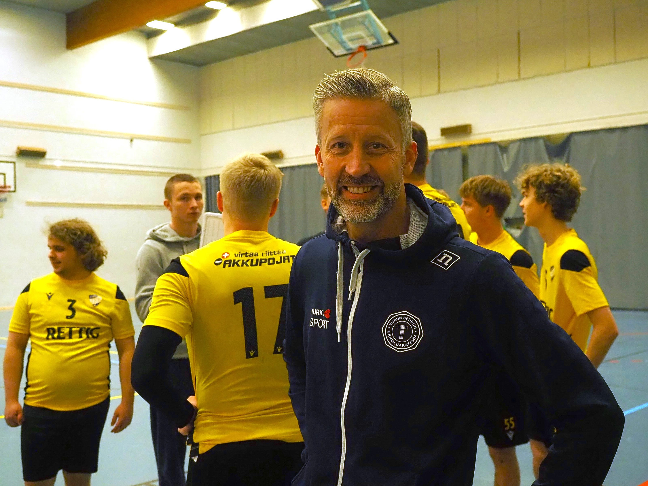 Gymnastiklärare står på en handbollsplan