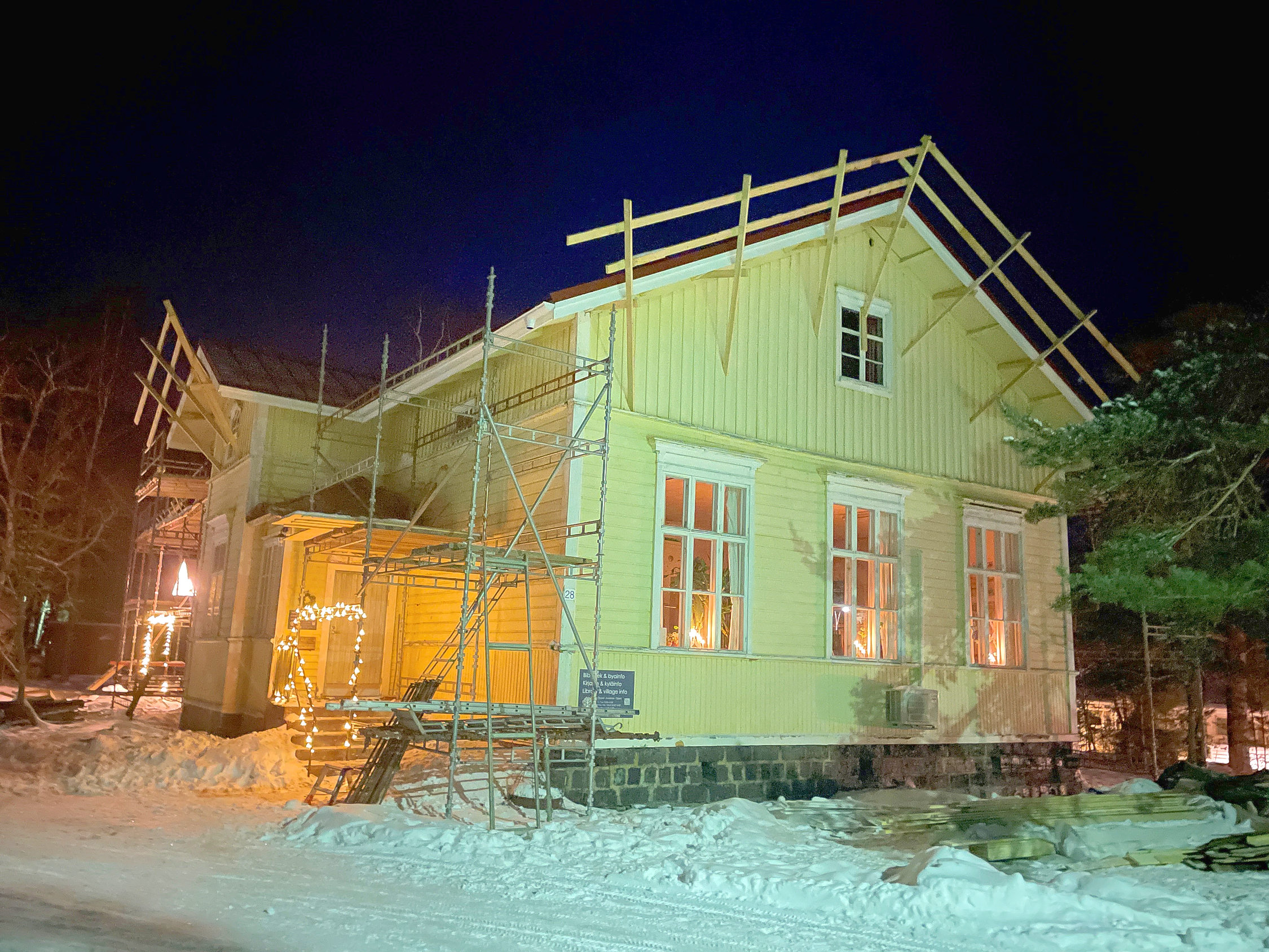 gult hus med byggställningar runtom.
