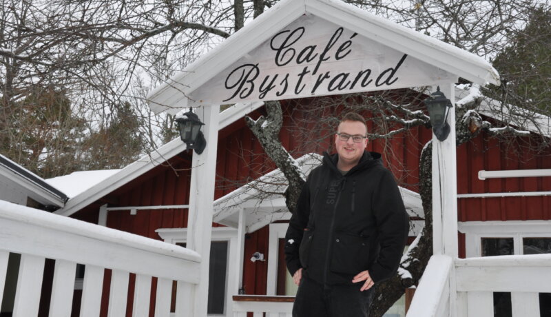 en man står vid ingången till en uteservering