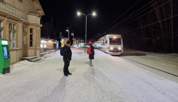 Tåg anlöper station i mörkret.