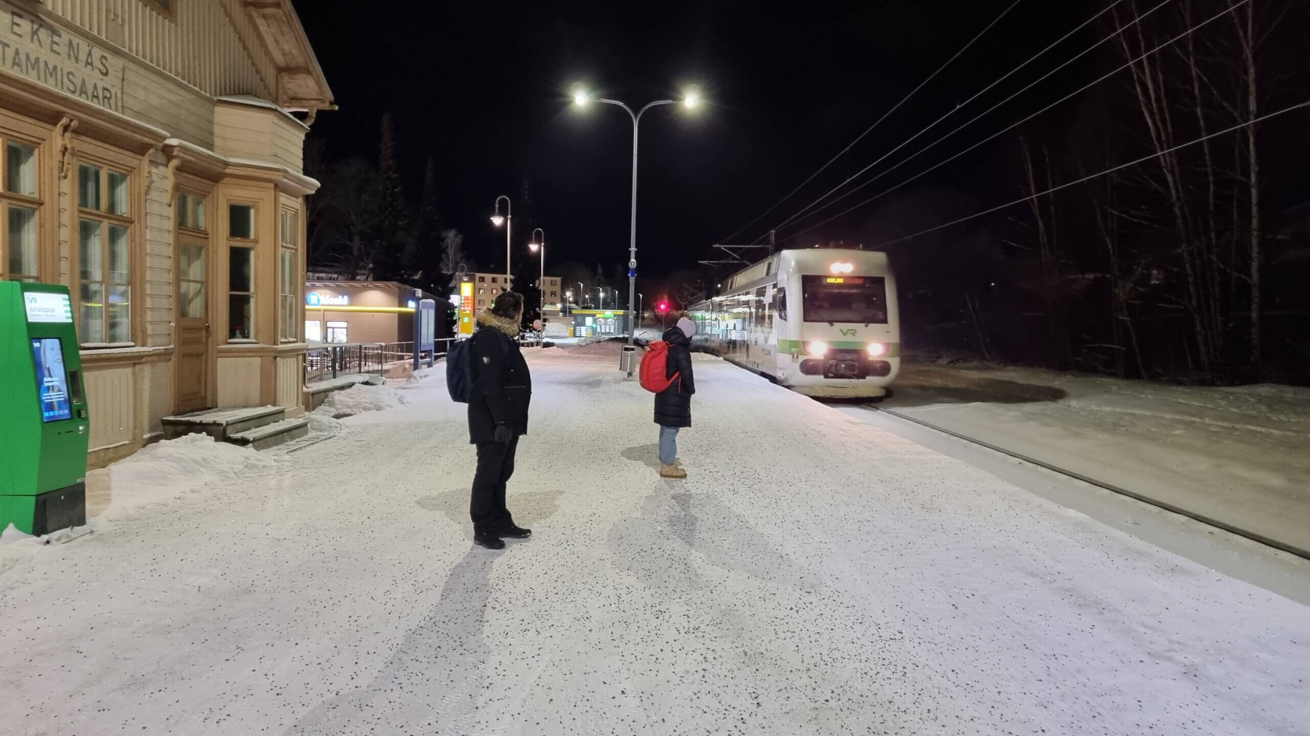 Tåg anlöper station i mörkret.