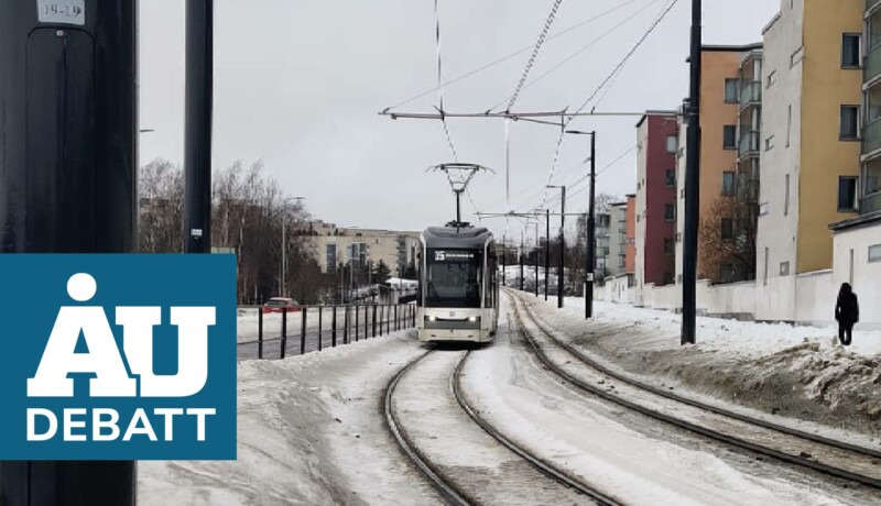 vit spårvagn närmar sig kameran, snö kring skenorna