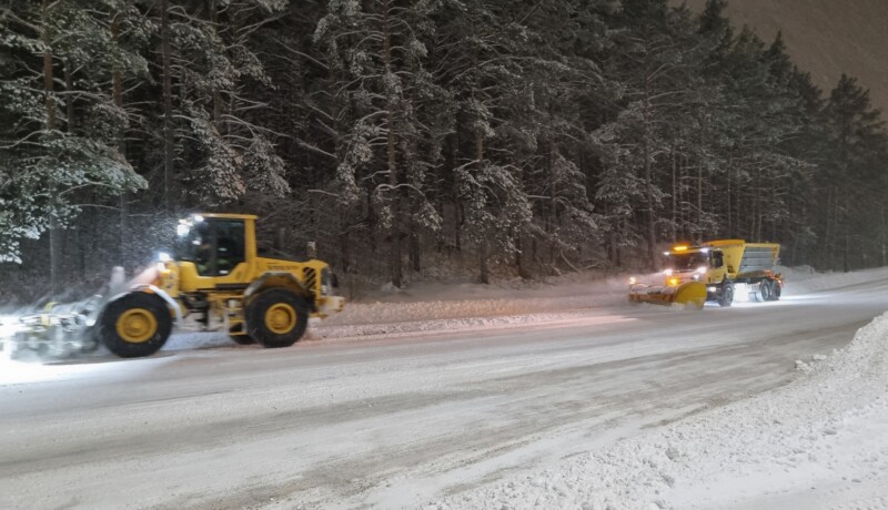 Två plogbilar på en snöig väg