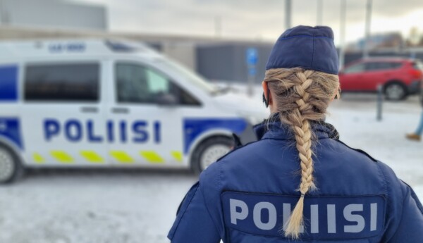 Kvinnlig polis vid polisbil.