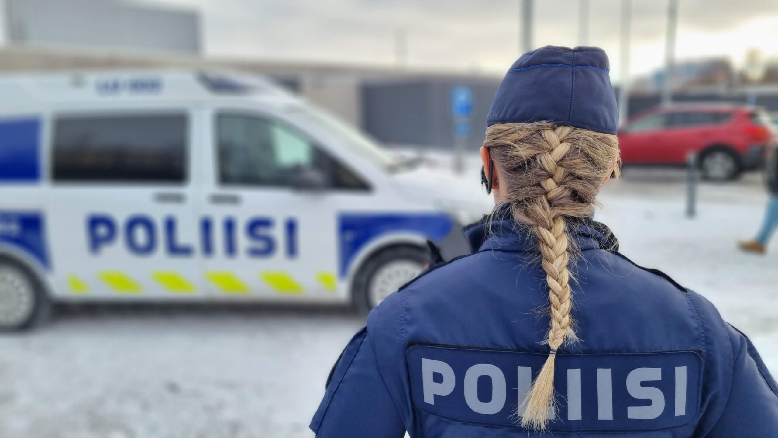 Kvinnlig polis vid polisbil.