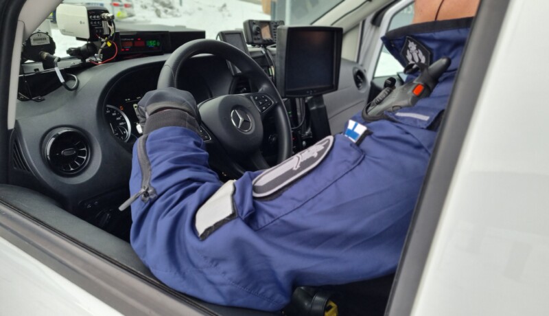 Polis bakom ratten i polisbil.