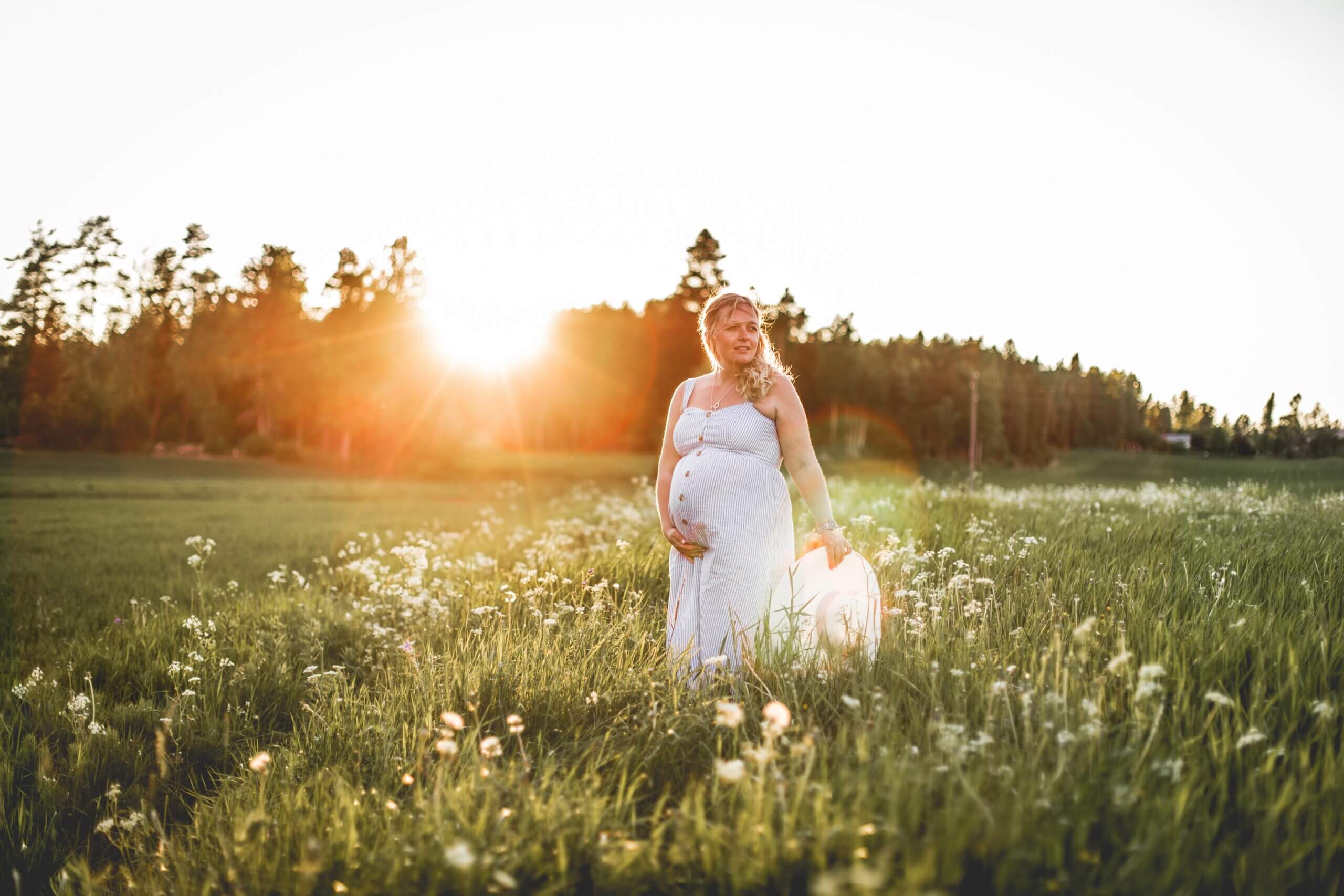 Gravid kvinna i solnedgång.