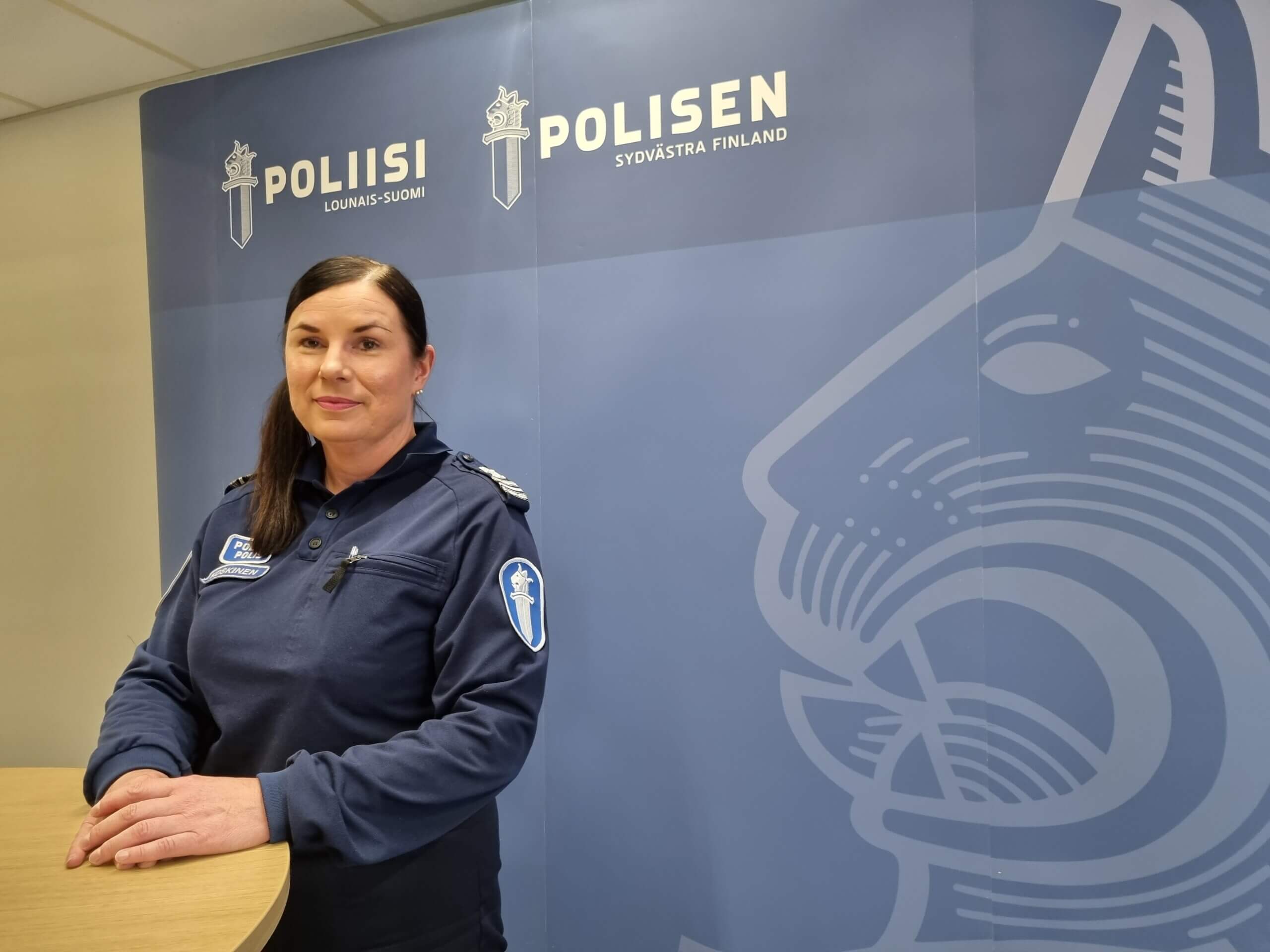 en poliskvinna står vid ett bord