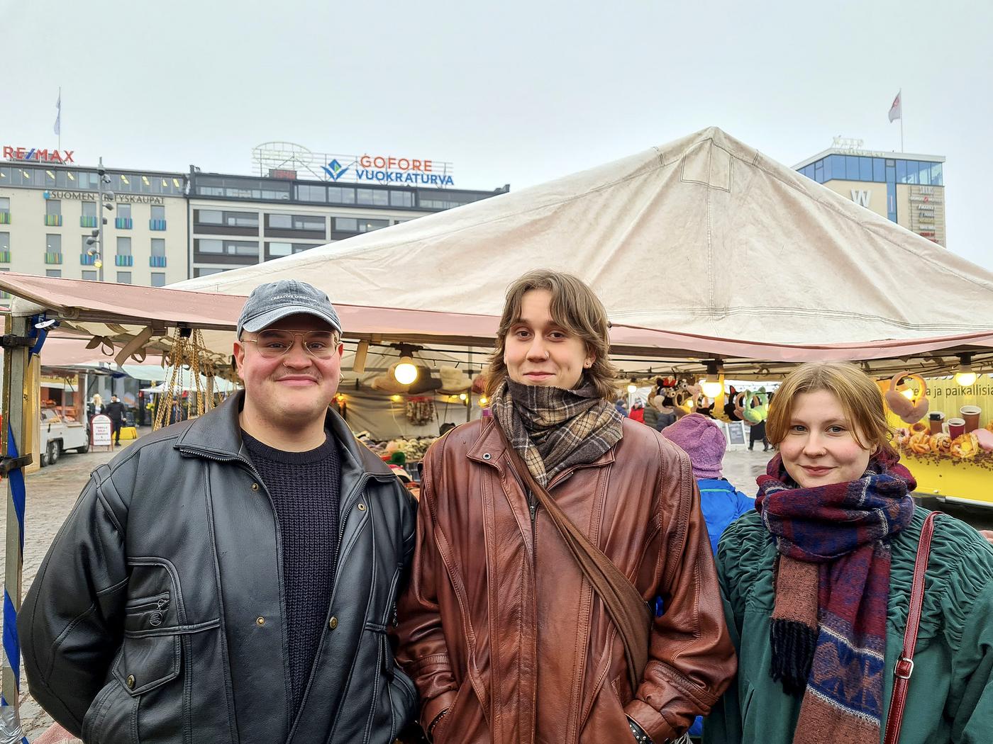 Tre unga personer på ett marknadstorg