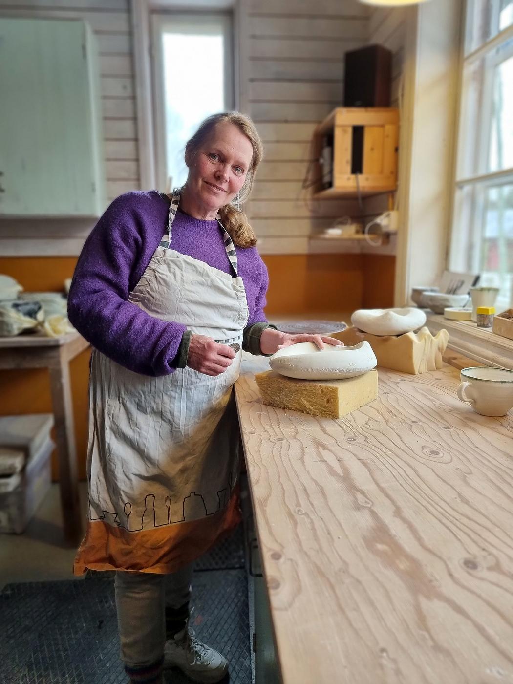 kvinna som arbetar med keramik i studio.