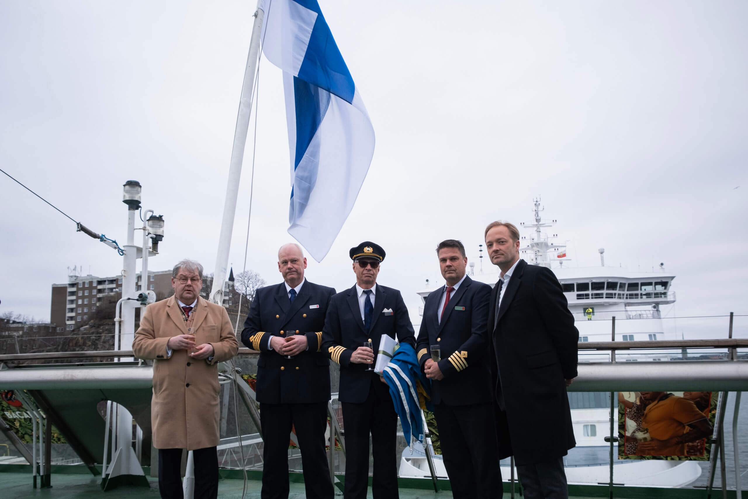 Fem herrar i uniform och ytterrockar ombord på ett fartyg