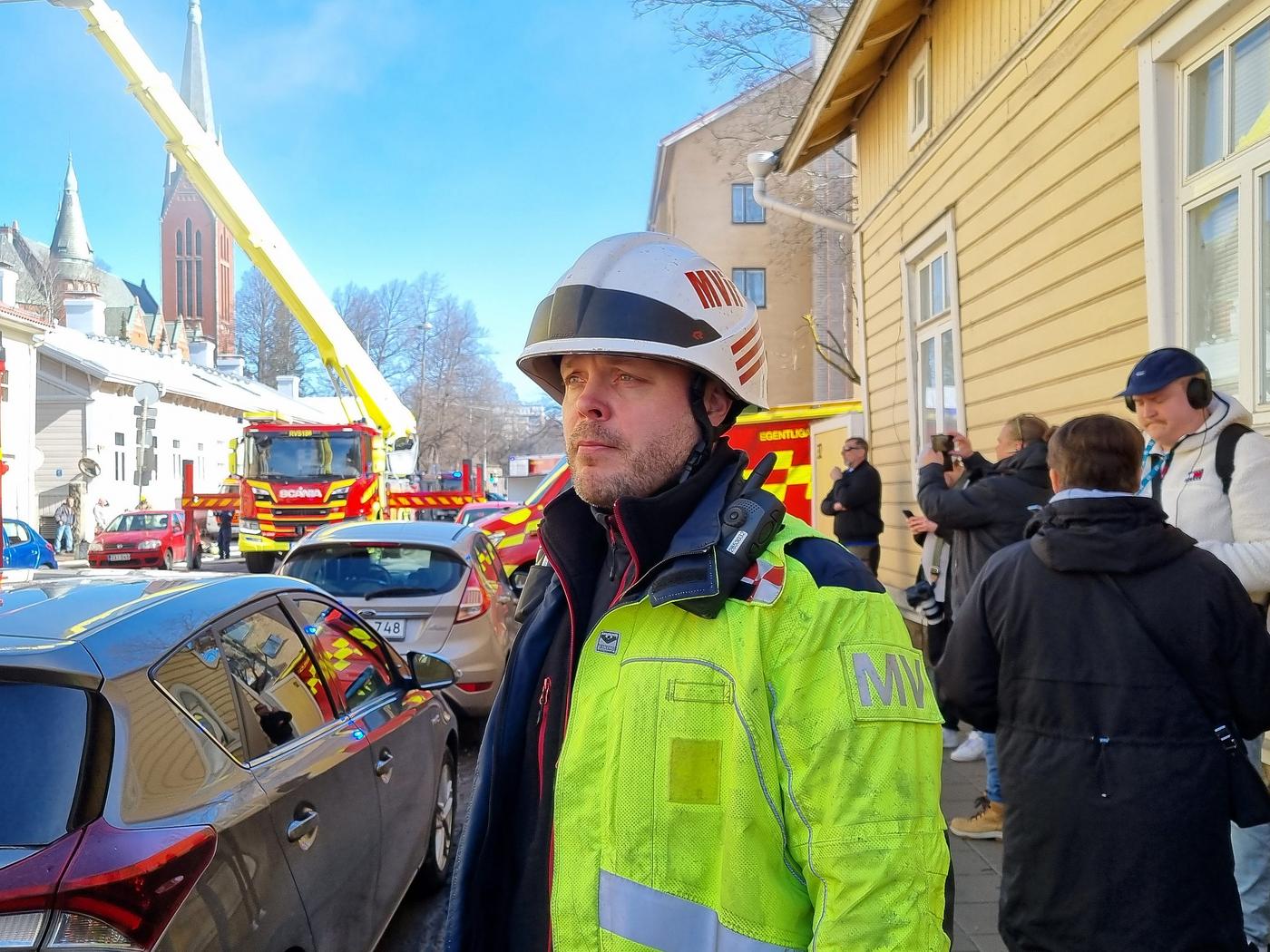 en brandman utanför ett brinnande hus