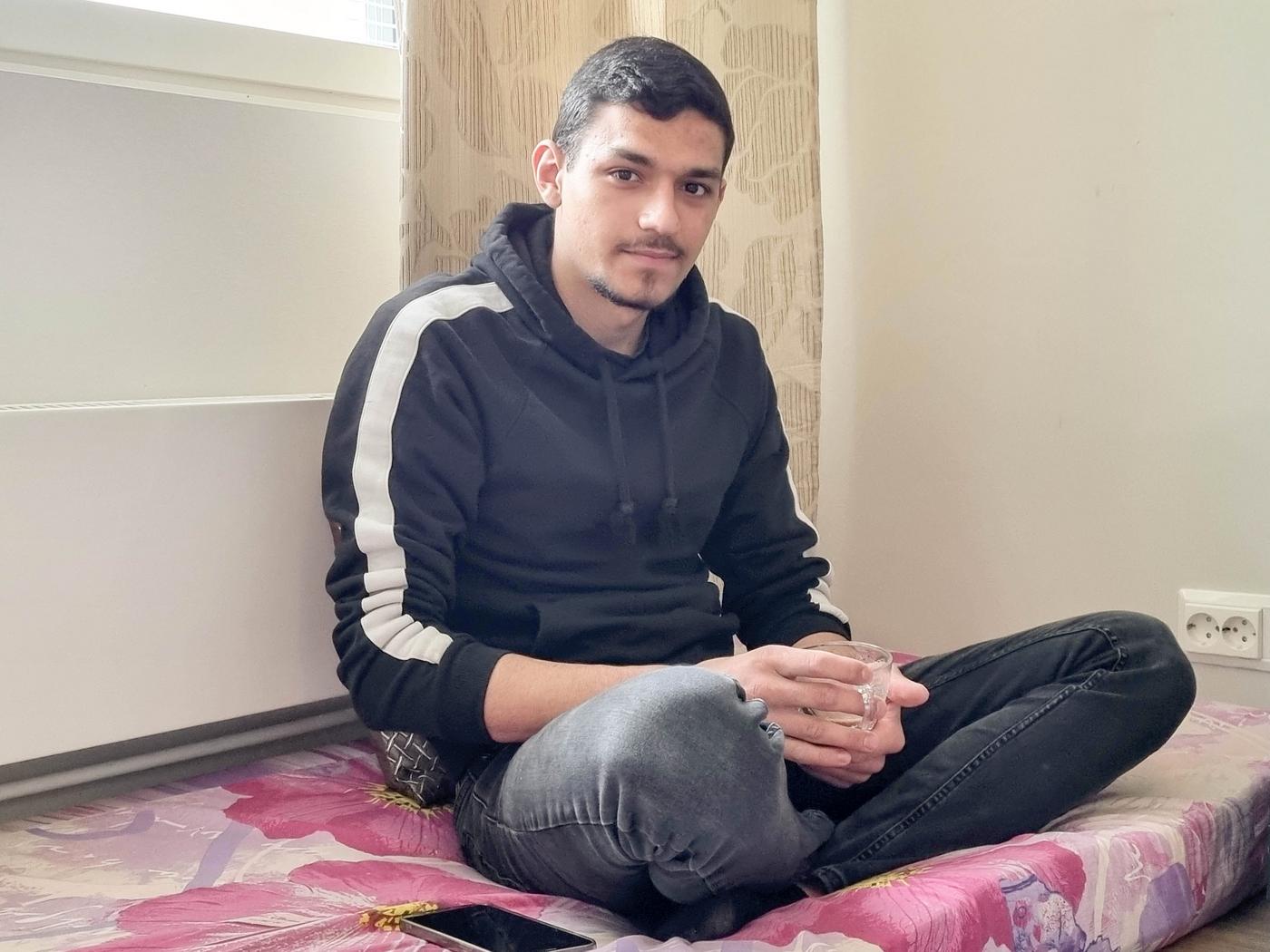 en man sitter i skärddarställning på en madrass