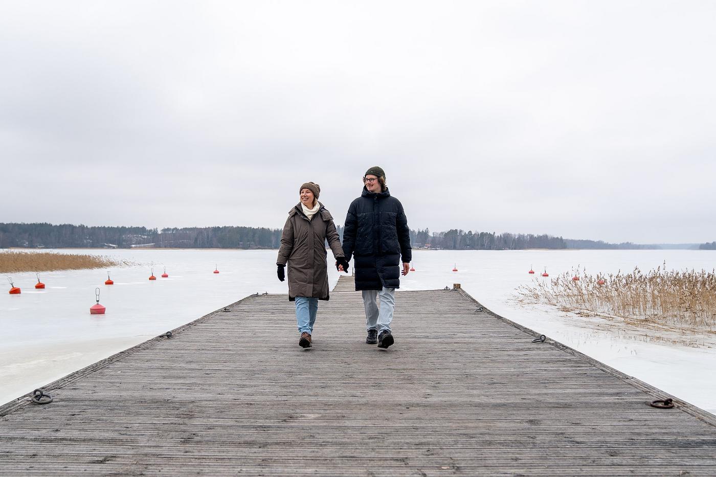Två personer på en brygga. Vinterväder.