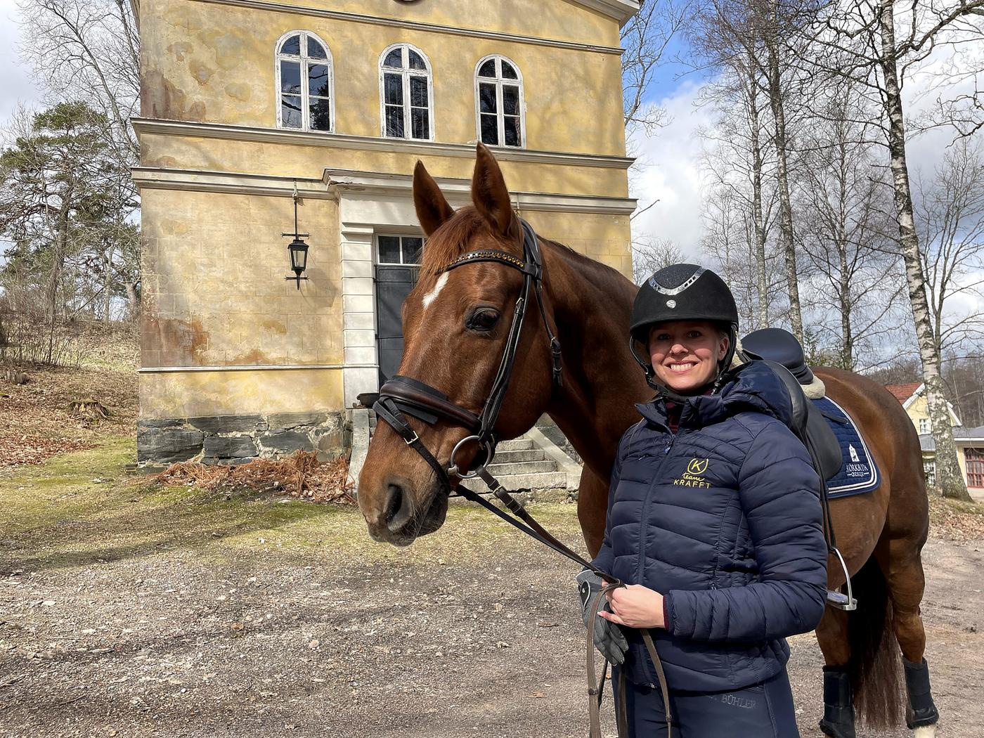 Kvinna och en häst i bruksmiljö