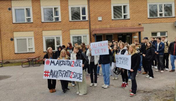 Studerande med plakat utanför skola.