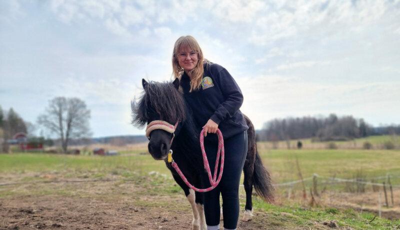 en kvinna med en svartvit ponny