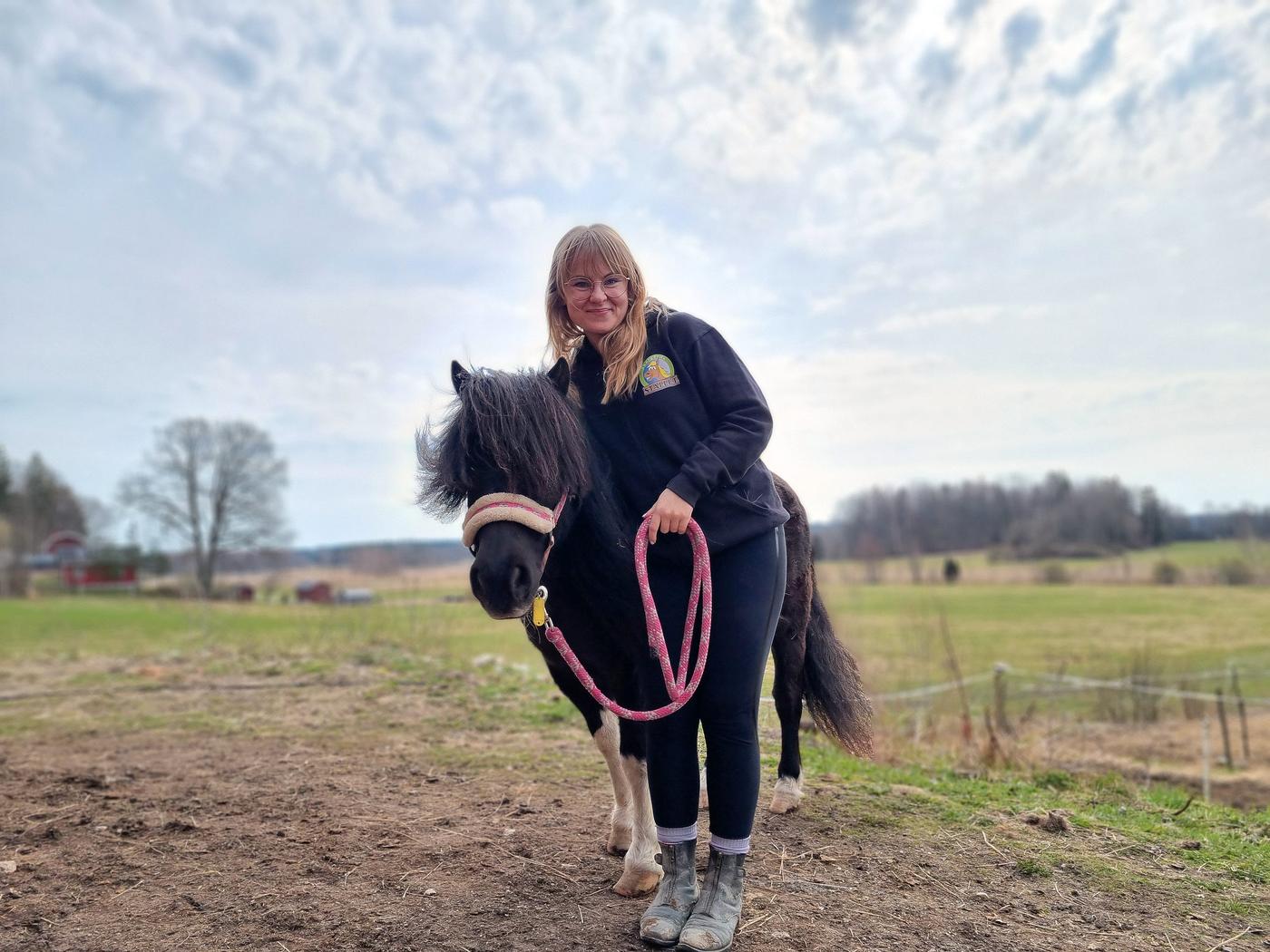 en kvinna med en svartvit ponny
