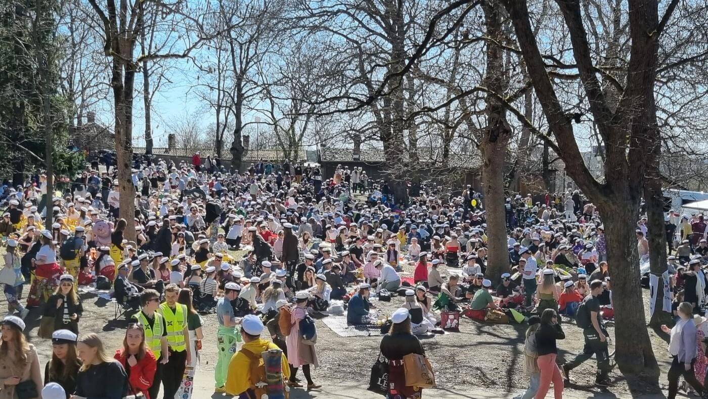 park i vårsol med massor av picknicksällskap