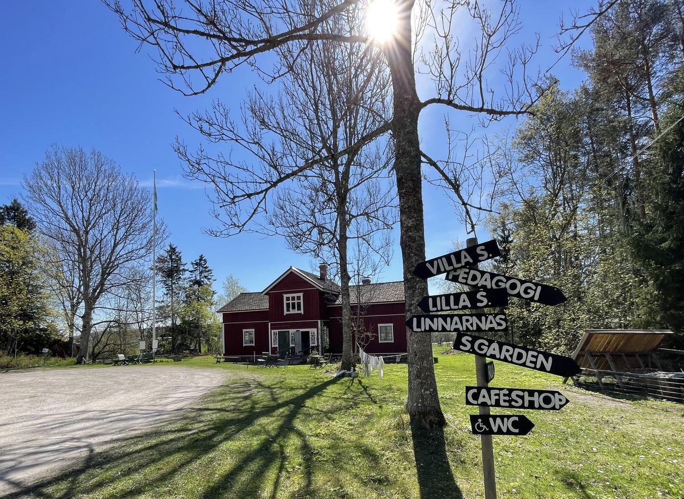 Parkliknande område och ett rött trähus