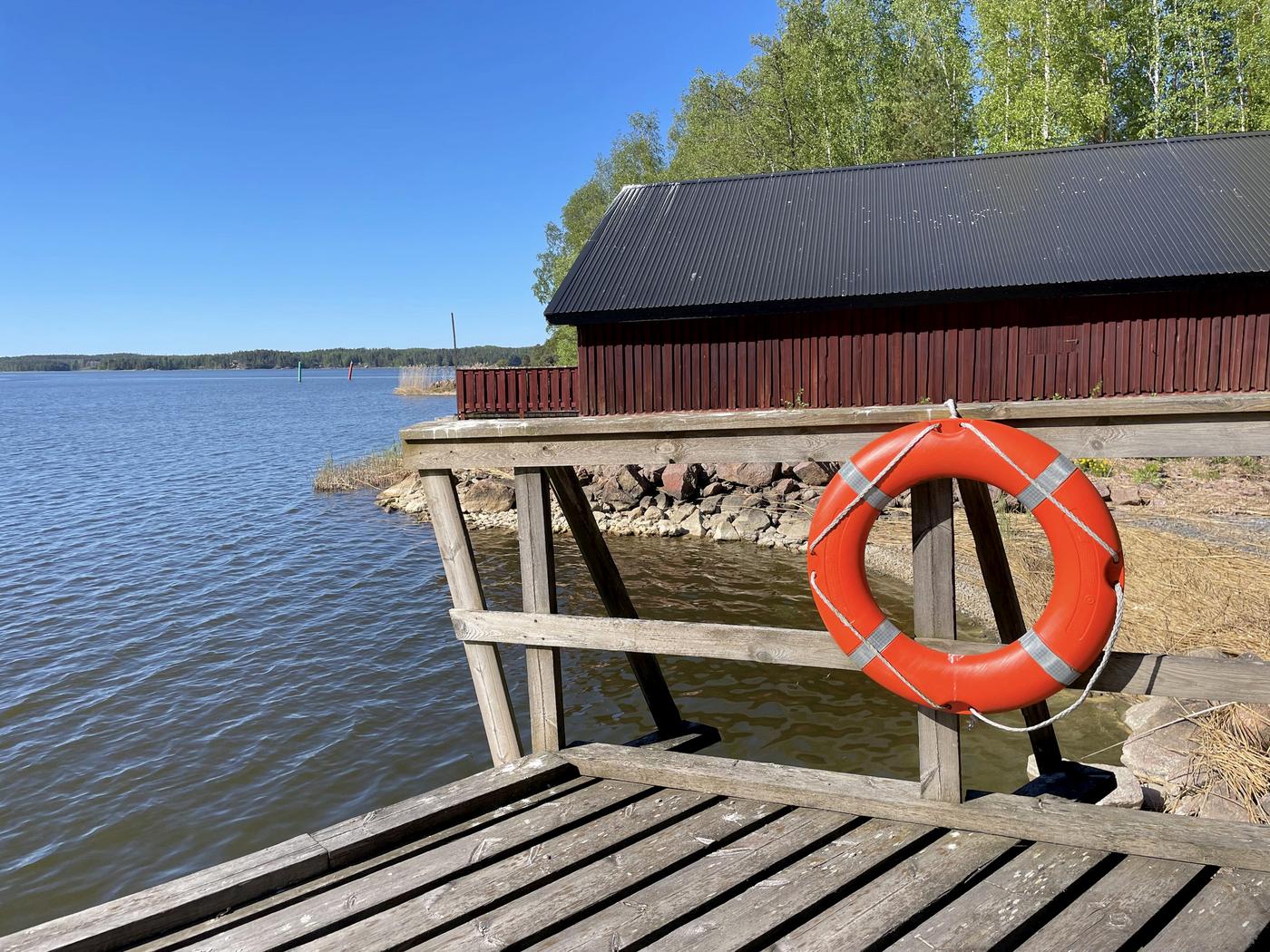 röd byggnad vid vatten fotad från en brygga