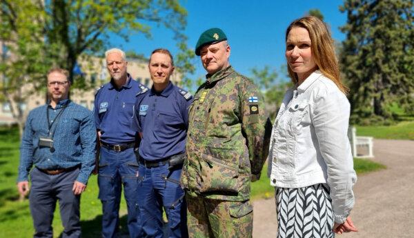 Civilklädda och uniformerade män och kvinnor i park.