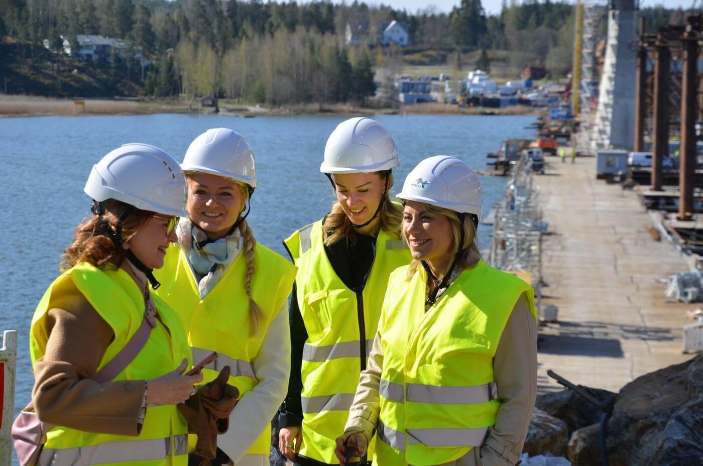 fyra leende kvinnor på en byggarbetsplats