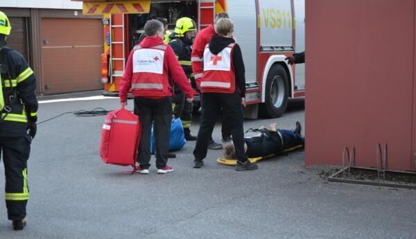 en brandbil och brandmän samt röda korsets frivilliga vid en bår