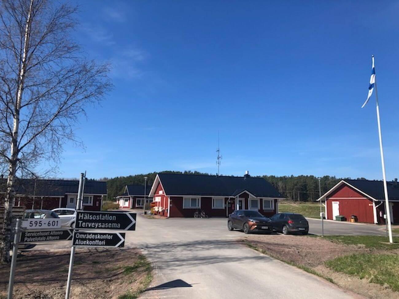 en vägkorsning med några röda hus i bakgrunden