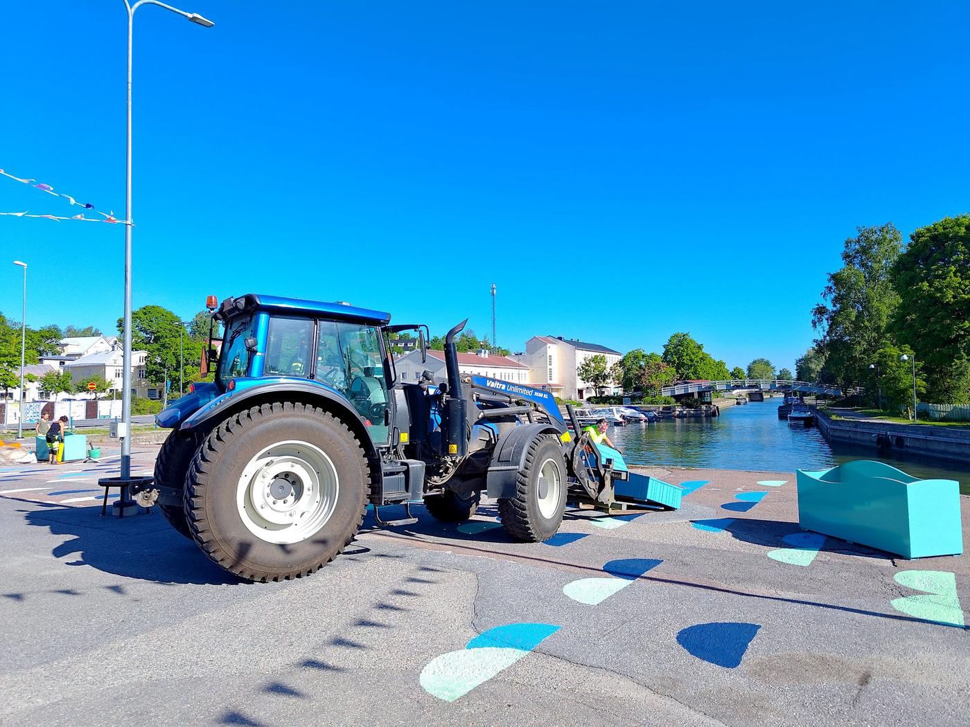 Traktor som ställer ner en blå trädivan