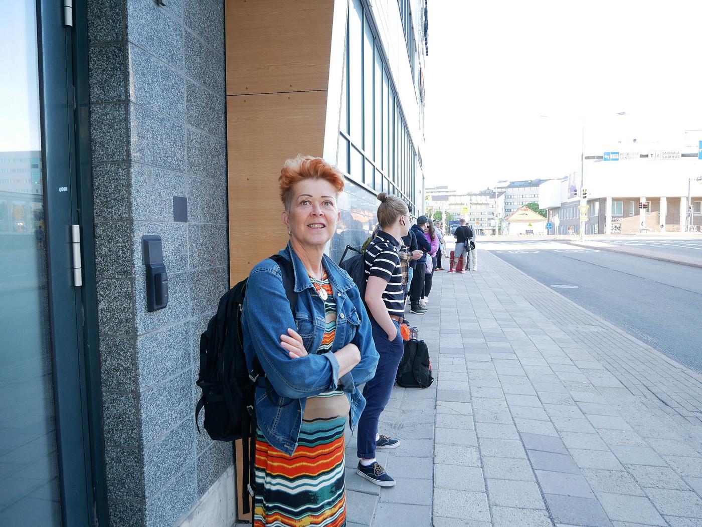 Person väntar på busshållplats.