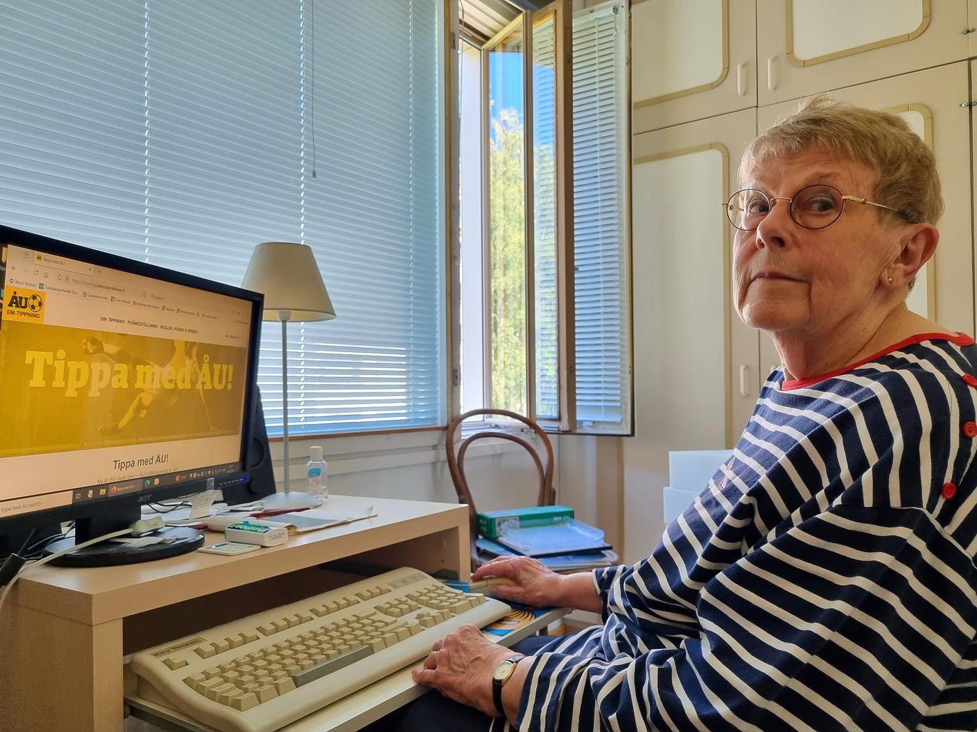 Äldre kvinna sitter vid ett datorbord