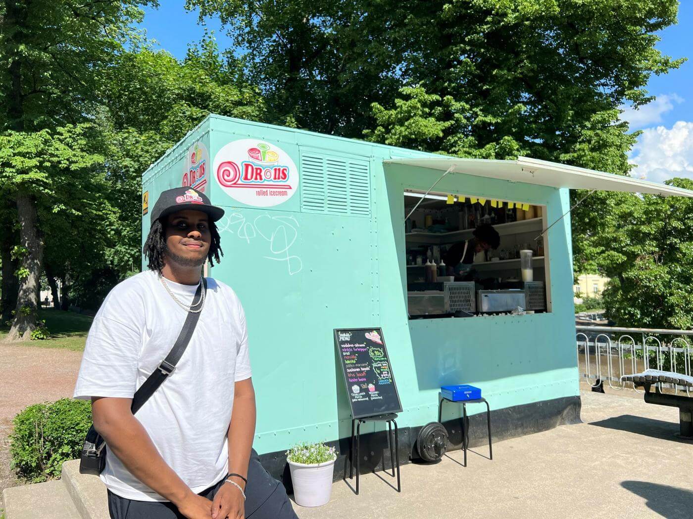 Ägaren står utanför glasskiosken.