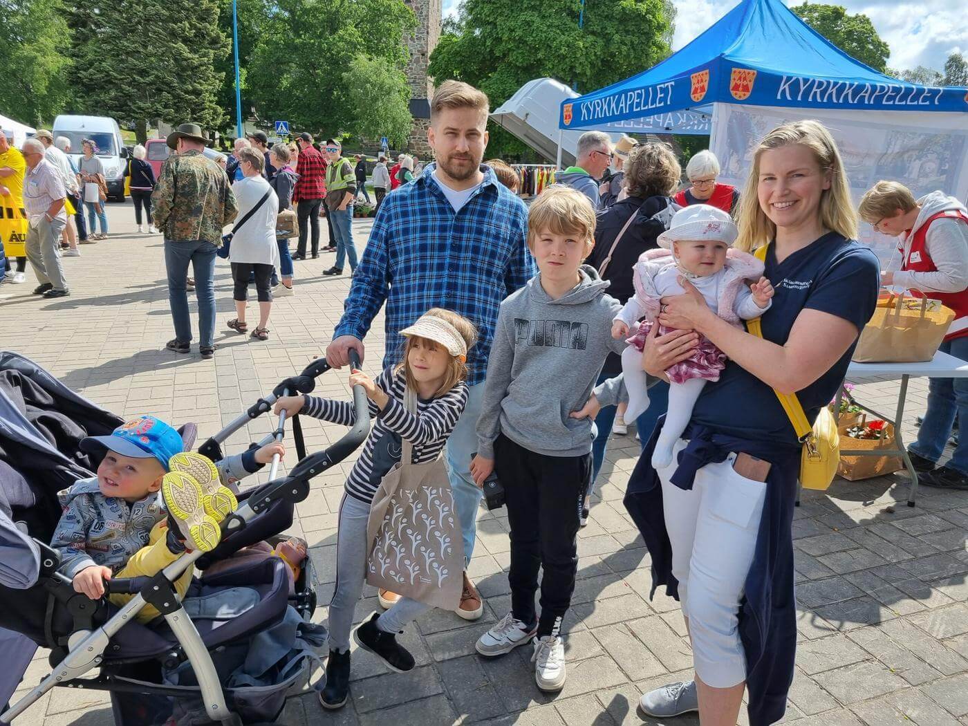 Familj som står på marknad på sommaren.