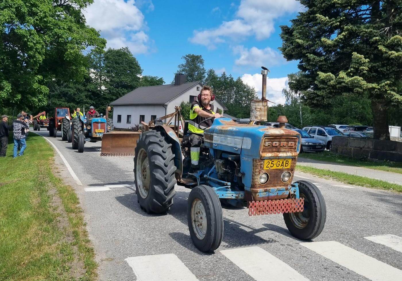 En blå traktor i traktorkavalkad på sommaren.
