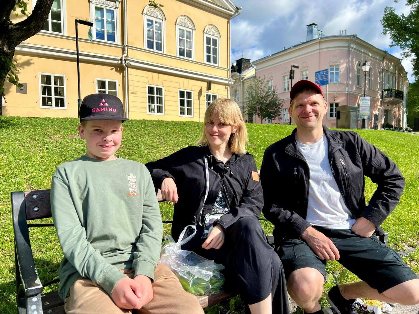 Unto Turunen, Niina Turunen och Oskari Turunen sitter på en bänk vid Aura å.