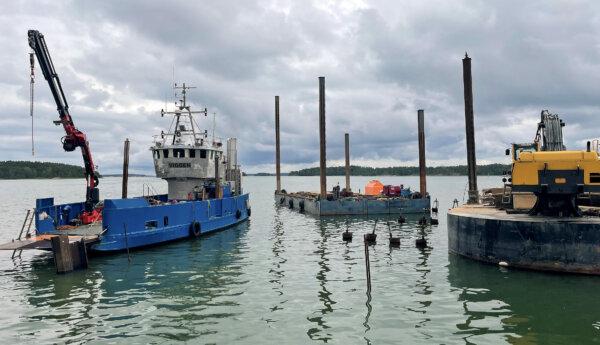 ett fartyg och två flottar för maskiner vid en strand