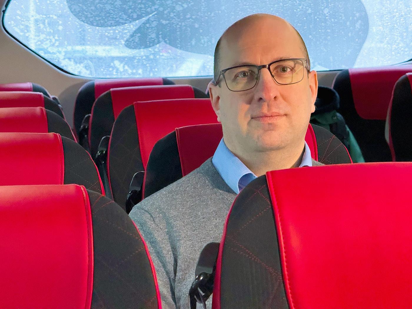 En man i en buss tittar mot kameran