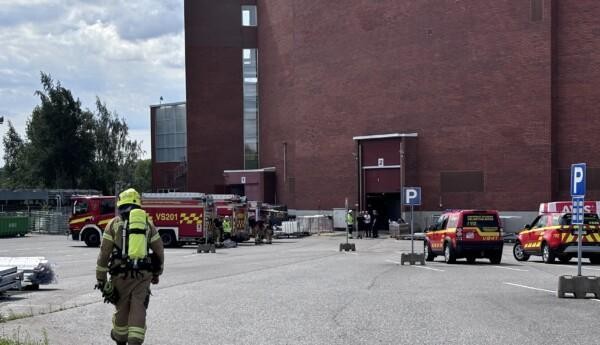 Brandbilar och brandsoldater utanför en hall.