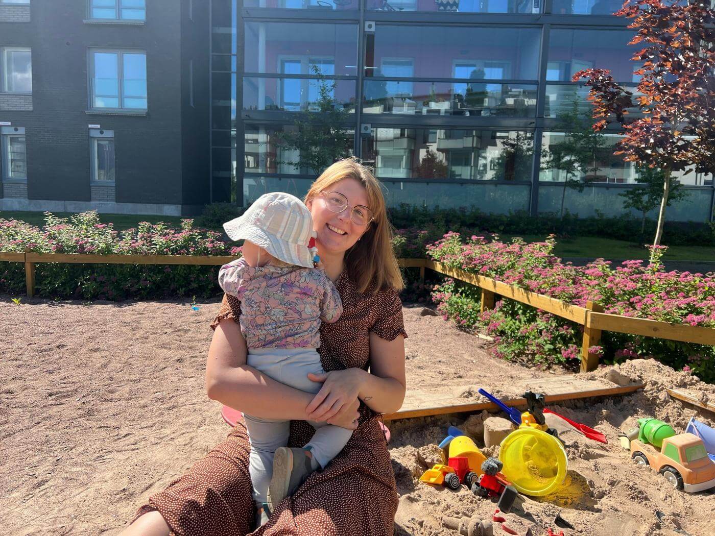 Maria Keränen och hennes barn leker i sandlådan.