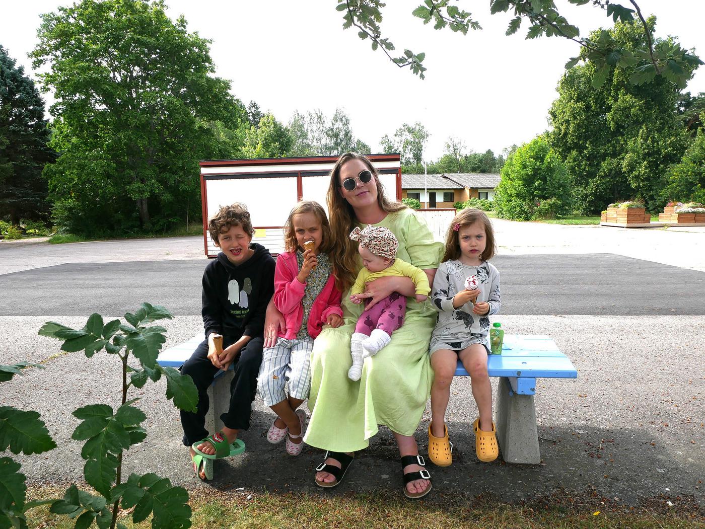 Familj sitter på bänk.