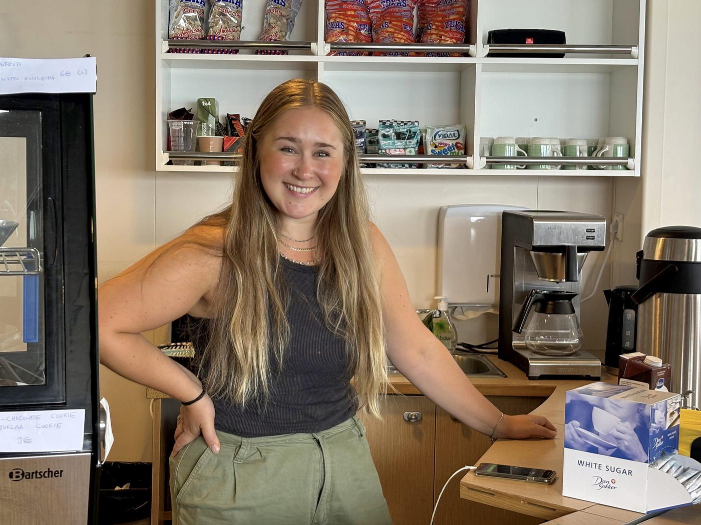 ung kvinna bakom disken i ett kafé
