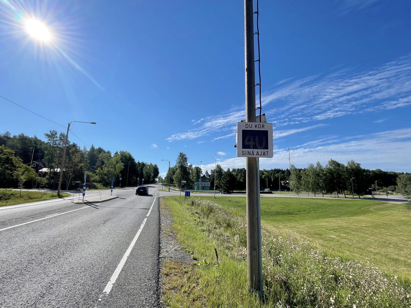 en hastighetstavla vid en asfalterad väg