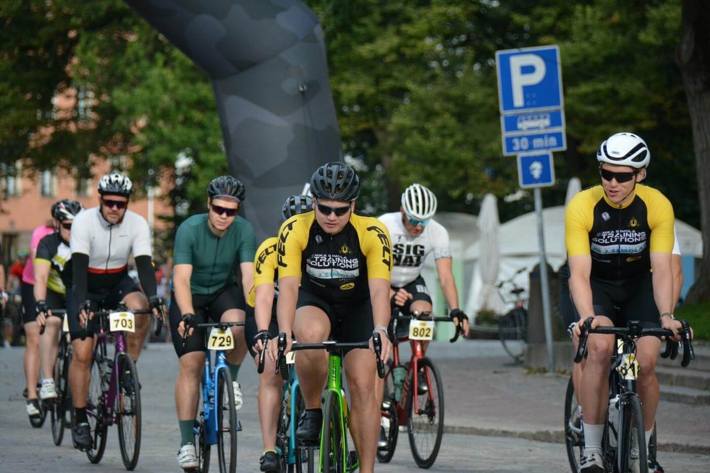 cyklister med hjälmar och solglasögon som deltar i lopp